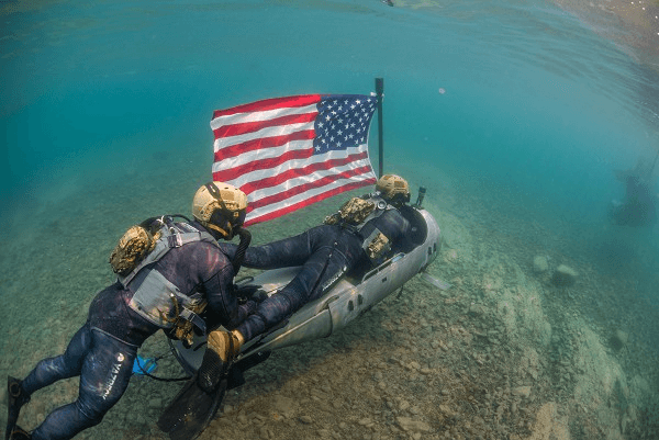 Combat divers surfacing with the U.S. flag